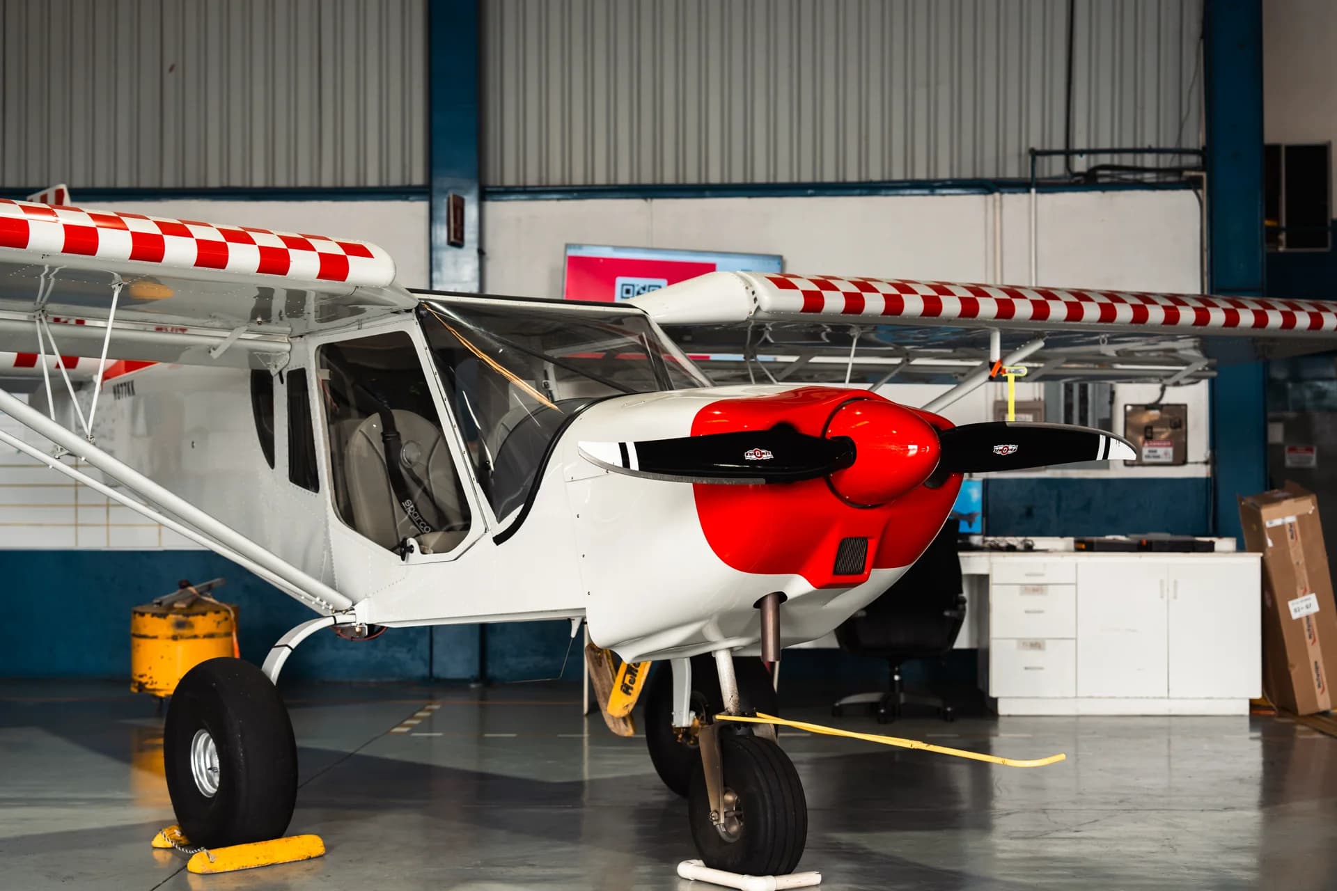 Red and white fixed-wing aircraft inside the Aerocorp hangar